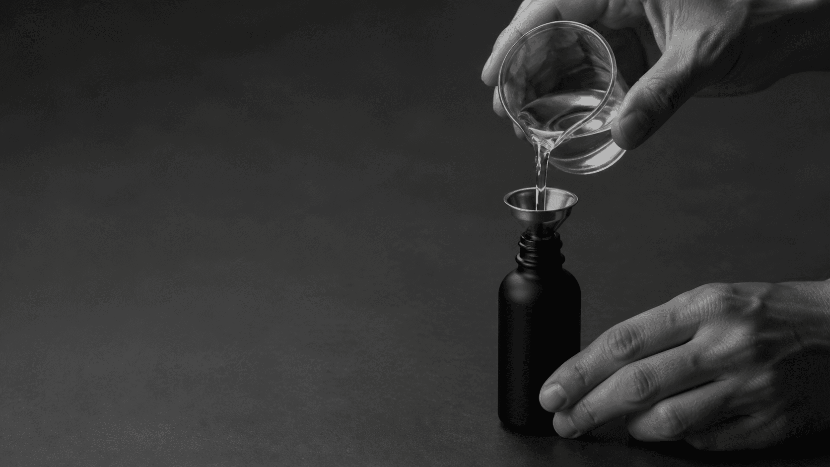 A formulation being decanted into a dark glass bottle